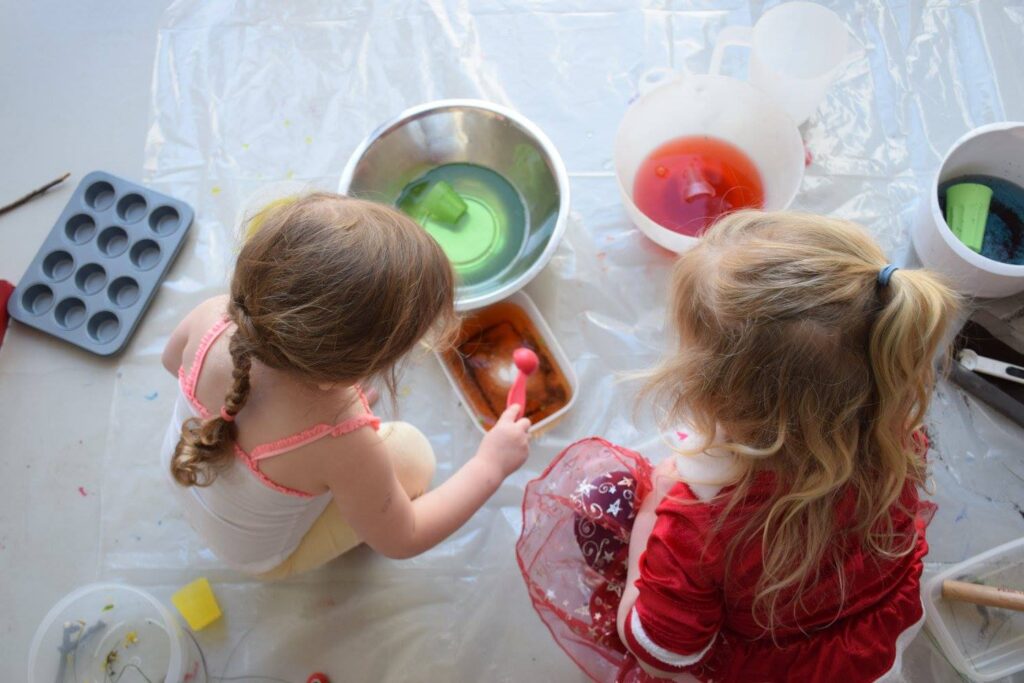 Two girls are taking part in the Create session, playing with natural colouring