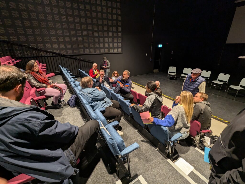 A group of people sit a in theatre, having a post-film discussion
