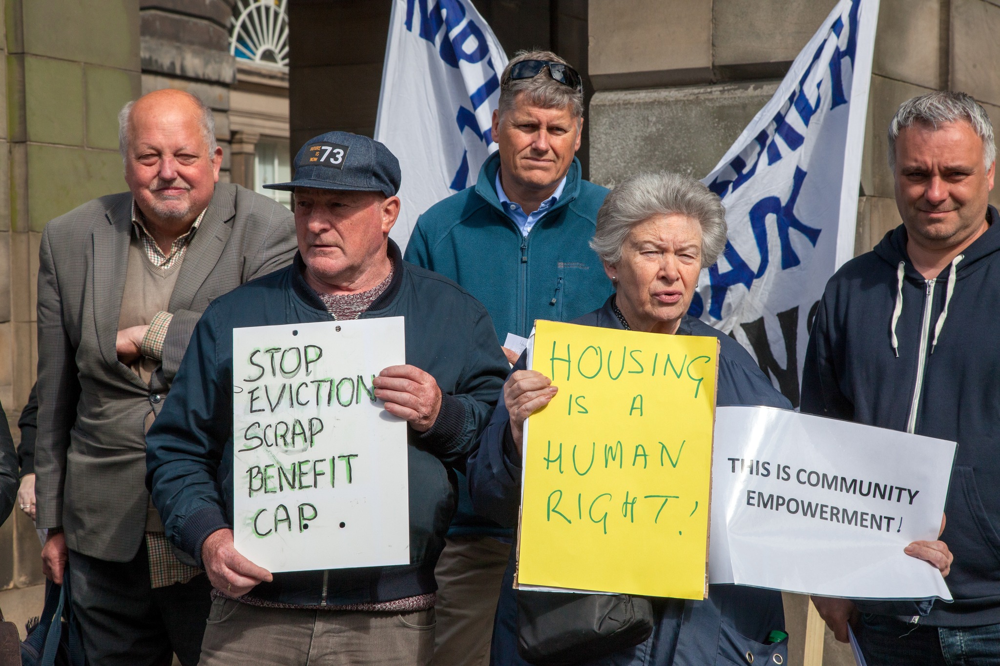 A group of people stand in a protest against the introduction of the 2017 Benefits and the evictions that followed; images taken by Craig Maclean